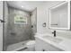Updated bathroom featuring a sleek, tiled shower and modern vanity with black hardware at 1158 Stroupe Rd, Kissimmee, FL 34744