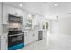 Well-lit kitchen with white cabinets, updated appliances, and window over the sink at 1158 Stroupe Rd, Kissimmee, FL 34744