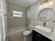 Bathroom with modern sink, round mirror, and new tile in renovated house at 1211 Lehigh St, Kissimmee, FL 34744