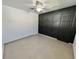 Spacious bedroom with a geometric accent wall, closet, tile floors, and ceiling fan at 1211 Lehigh St, Kissimmee, FL 34744