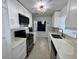 Bright white kitchen featuring modern cabinets, stainless steel appliances, and a stylish light fixture at 1211 Lehigh St, Kissimmee, FL 34744