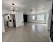 Open-concept living space with tiled floors, leading into a modern kitchen with white cabinets at 1211 Lehigh St, Kissimmee, FL 34744