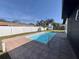 Backyard pool with tiled patio, white fence, and well-maintained lawn at 1211 Lehigh St, Kissimmee, FL 34744