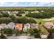 A neighborhood featuring single-Gathering houses interspersed with green spaces and a golf course beyond the trees at 1225 Radiant St, Reunion, FL 34747