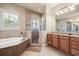 Beautiful bathroom featuring a soaking tub, tiled glass shower, granite countertops, and a bright window at 1225 Radiant St, Reunion, FL 34747