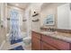 A bathroom features a shower-tub combo, blue accents, and granite countertops at 1225 Radiant St, Reunion, FL 34747