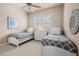 Comfortable bedroom with two twin beds, neutral walls, ceiling fan, and shuttered windows at 1225 Radiant St, Reunion, FL 34747