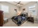 Cozy bedroom features a paisley patterned bedspread, ceiling fan, neutral walls, and shuttered windows at 1225 Radiant St, Reunion, FL 34747