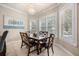 Bright dining area with a chandelier and natural light, featuring shutters and views of the pool at 1225 Radiant St, Reunion, FL 34747