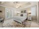 A bright main bedroom with a ceiling fan, shutters, and patio doors to outside at 1225 Radiant St, Reunion, FL 34747
