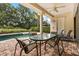 Relaxing covered patio with ceiling fan, stone columns, an outdoor dining set, and pool access at 1225 Radiant St, Reunion, FL 34747