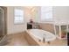 Bright bathroom with a large soaking tub, tiled surround, and natural light from a window at 1776 Bella Lago Dr, Clermont, FL 34711