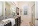 Bathroom featuring granite counters, dark cabinets, and a glass-enclosed shower at 1776 Bella Lago Dr, Clermont, FL 34711