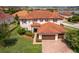 Elegant two-story home featuring a red tile roof, manicured lawn, and a spacious three-car garage at 1776 Bella Lago Dr, Clermont, FL 34711