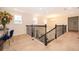 Upstairs hallway overlooking staircase, with iron railing and lots of natural light at 1776 Bella Lago Dr, Clermont, FL 34711