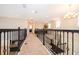 Bright upper hallway featuring iron railing, neutral carpet, and recessed lighting at 1776 Bella Lago Dr, Clermont, FL 34711