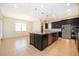 Modern kitchen featuring a large island, dark cabinets, and stainless steel appliances at 1776 Bella Lago Dr, Clermont, FL 34711