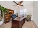 Spacious home office with built-in shelving, large desk, and a comfortable sitting area; plantation shutters provide privacy at 1776 Bella Lago Dr, Clermont, FL 34711