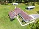 Aerial shot highlights a charming house with well-manicured lawn, carports, and mature trees at 1781 Terra Verde Ln, Chuluota, FL 32766