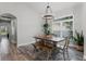 Bright dining area featuring a modern chandelier, large windows, and stylish wood-look tile flooring at 1781 Terra Verde Ln, Chuluota, FL 32766