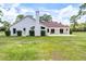 Exterior view of the home featuring a spacious green lawn, a covered patio and a chimney at 1781 Terra Verde Ln, Chuluota, FL 32766