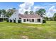 Exterior view of the property featuring a large green lawn, a covered patio and outbuildings at 1781 Terra Verde Ln, Chuluota, FL 32766