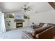 Cozy living room with a fireplace, a modern ceiling fan, and a comfortable, oversized leather sofa at 1781 Terra Verde Ln, Chuluota, FL 32766