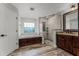 The main bathroom offers a walk-in shower, separate tub, and dark wood cabinetry at 1781 Terra Verde Ln, Chuluota, FL 32766