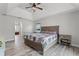 Bright main bedroom with a tray ceiling, wood-look tile flooring, and natural light from a window at 1781 Terra Verde Ln, Chuluota, FL 32766