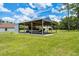Open metal outbuilding with a boat and trailer that is set back from the home on a large lawn at 1781 Terra Verde Ln, Chuluota, FL 32766