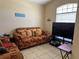 Cozy living room with a patterned sofa, tile floors, and a large window offering plenty of natural light at 2106 Congress Ln, St Cloud, FL 34769