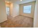 Cozy bedroom with neutral carpet, natural light from a window, and a doorway leading to the rest of the house at 2278 Tay Wes Dr, St Cloud, FL 34771