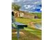 Beautiful exterior of a home with a pond view, lush green lawn, and a lakeside bench at 2281 Royal Ridge Dr, Davenport, FL 33896
