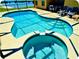 Beautiful kidney-shaped pool and spa with built-in steps, surrounded by a spacious patio and outdoor seating at 2281 Royal Ridge Dr, Davenport, FL 33896