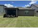 Spacious backyard with lush green grass and a screened in patio at 2436 Gratia Pl, Casselberry, FL 32707