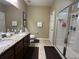Well-lit bathroom featuring double sinks, granite countertops, and a walk-in shower at 2436 Gratia Pl, Casselberry, FL 32707
