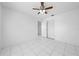This bedroom has white tile floors, a ceiling fan, and a closet with louvered doors at 2637 Debany Rd, Kissimmee, FL 34744