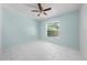 Bedroom with bright-blue walls features a large window, a ceiling fan, and tile floors at 2637 Debany Rd, Kissimmee, FL 34744