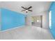 Bedroom with blue accent wall, tile floors, ceiling fan, and patio access at 2637 Debany Rd, Kissimmee, FL 34744
