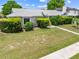 Landscaped front yard with mature bushes, trees, and green lawn at 2637 Debany Rd, Kissimmee, FL 34744