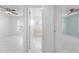 Hallway view of a bathroom and bedrooms with tile floors, doors, and ceiling fans at 2637 Debany Rd, Kissimmee, FL 34744