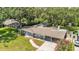 Aerial view highlighting the home's layout, mature landscaping, pool, screened-in lanai, and long driveway at 2727 Easton Ter, Lakeland, FL 33803