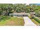 Aerial view of a single-Gathering home featuring lush greenery, mature trees, and a lengthy driveway at 2727 Easton Ter, Lakeland, FL 33803