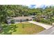 Aerial view of a home with a long driveway, mature trees, and lush green lawn, close to neighborhood streets at 2727 Easton Ter, Lakeland, FL 33803