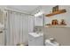 Cozy bathroom with white shower curtain, vanity, toilet, and decorative shelves at 2727 Easton Ter, Lakeland, FL 33803