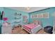 Charming bedroom featuring bright walls, shelves, comfortable bed, and hardwood floors at 2727 Easton Ter, Lakeland, FL 33803