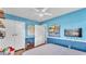 Cozy blue bedroom featuring storage shelves, a comfortable bed, and a mounted TV at 2727 Easton Ter, Lakeland, FL 33803