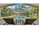 Screened pool area featuring lounge chairs and a table for relaxation and enjoying the outdoors at 2727 Easton Ter, Lakeland, FL 33803