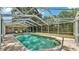 A screened in pool with clear water and a ladder, surrounded by ample patio space and lush landscaping at 2727 Easton Ter, Lakeland, FL 33803