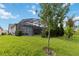 Wide shot of the home's screened in pool and lanai from the expansive lawn at 2772 Southland St, St Cloud, FL 34772